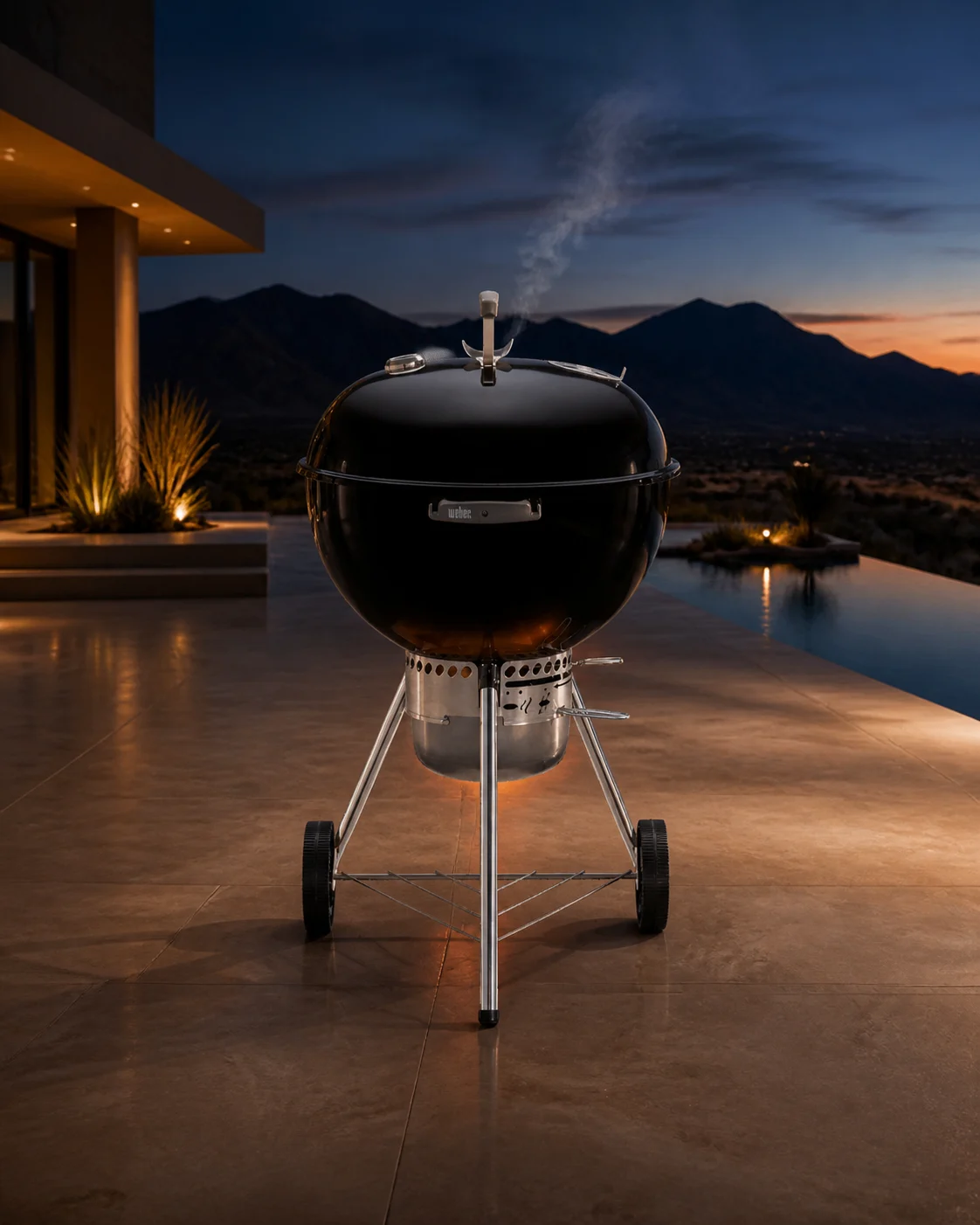 The same Weber Original Kettle Premium charcoal grill in a premium desert-home campaign scene at blue hour.
