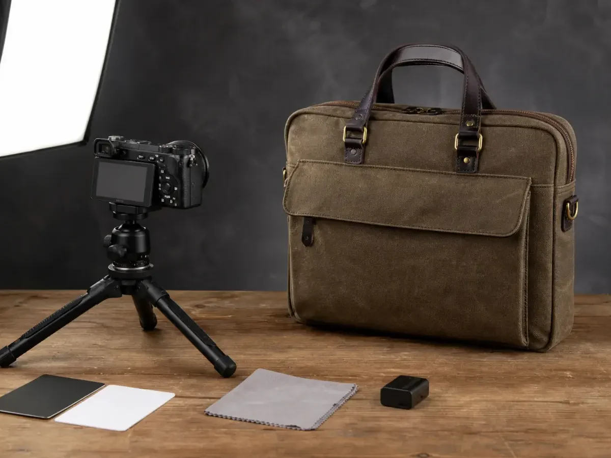 A messenger bag staged beside a compact camera rig and reference cards.