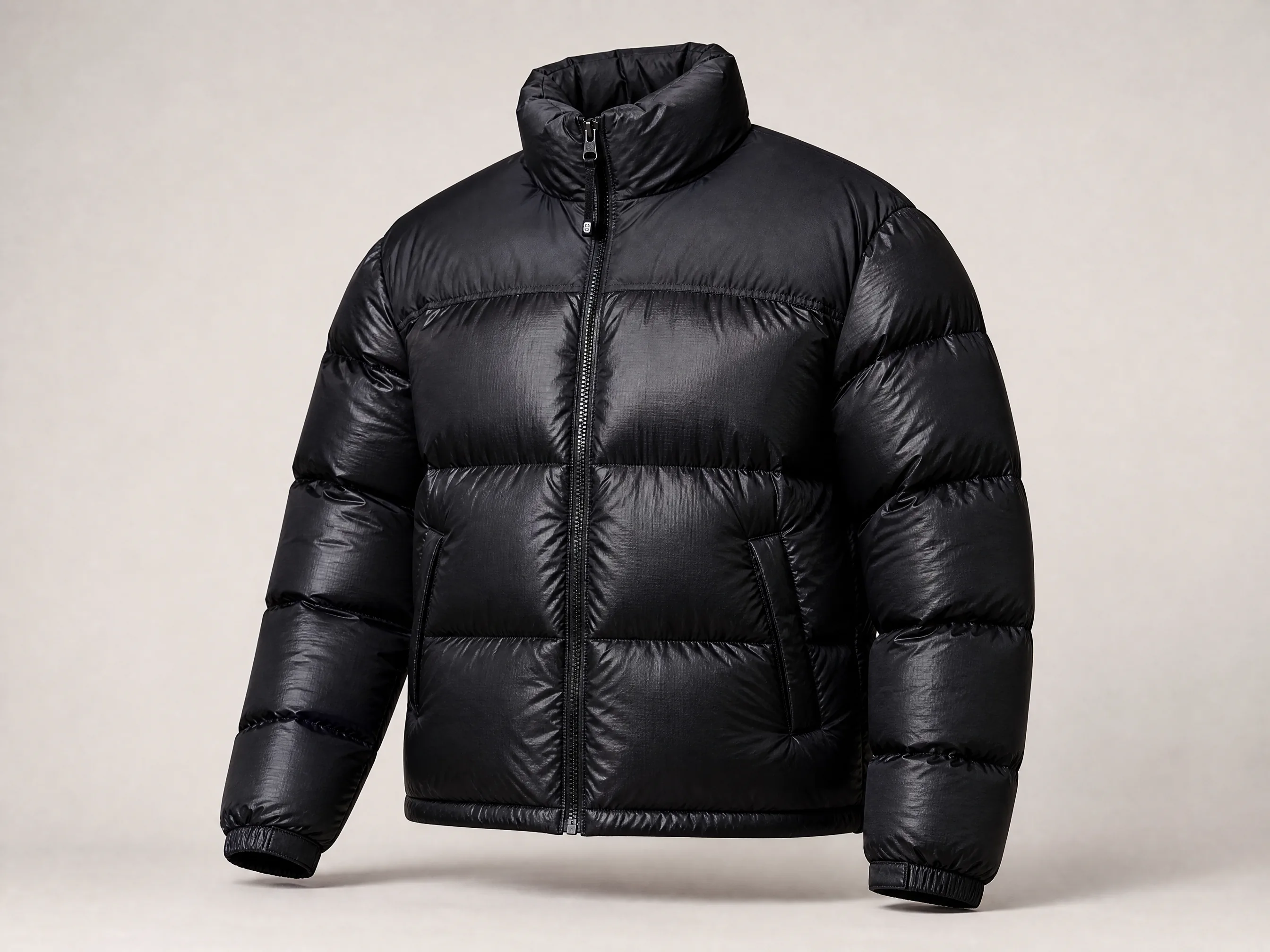 A black quilted puffer jacket photographed to show its full shape and construction.